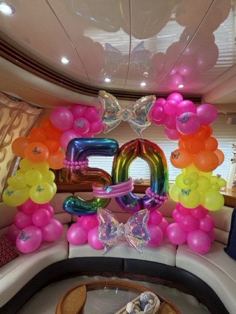 Happy Birthday banner with balloon clusters on deck