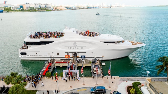 Formal dinner tables with city lights backdrop onboard event vessel